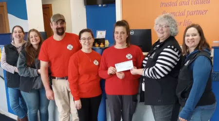 Community Foundation of Northeast Michigan Youth Advisory Council Members pose with a $505.00 check and posters advertising YAC Day